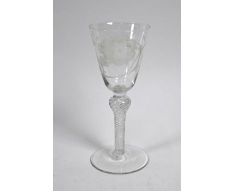 An antique Jacobite wine glass, the tapering bowl wheel-etched with rose decoration and lens-centred star motif, on air-twist