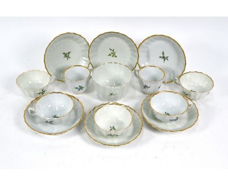 A First Period Worcester part tea service, sparsely painted with green flowers within gilt rims, comprising six saucers, thre