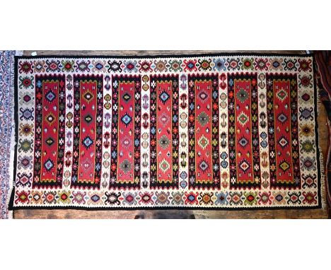 A vintage Caucasian kelim, the multi-banded design of stylised flower heads on red/camel ground, 200 cm x 99 cm