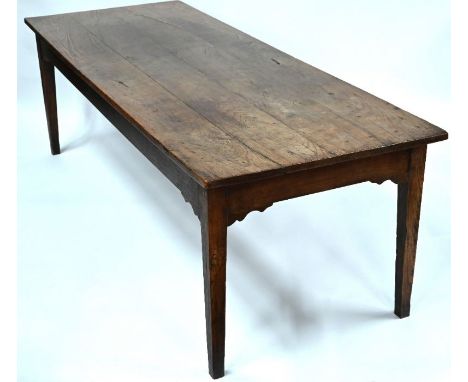 A large antique French provincial elm and fruitwood dining table, the plank top raised on square tapering legs, 239 cm long x