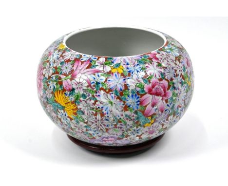 A Chinese famille rose millefleur bowl of compressed globular form, painted in bright polychrome enamels with an abundance of