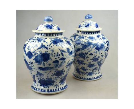 A matched pair of Chinese blue and white porcelain vases and covers each decorated with birds and butterflies on a flower str