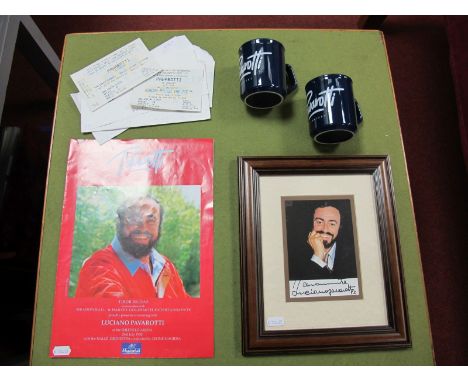 A Framed Photographic Portrait, with autograph of Luciano Pavarotti (unverified), associated mugs, concert programme and tick