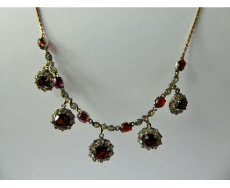 An Antique 9 ct Garnet & White Stone Necklace, the necklace set with five graduated garnets in floral mounts with six cabacho