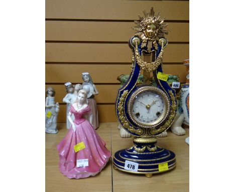 A reproduction gilt & blue French Marie Antoinette-style mantel clock in the form of a lyre together with a Coalport figurine