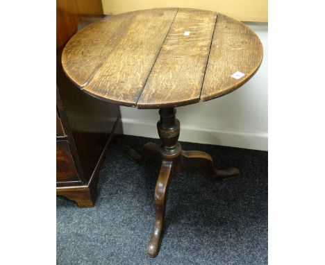 An antique circular top tripod table