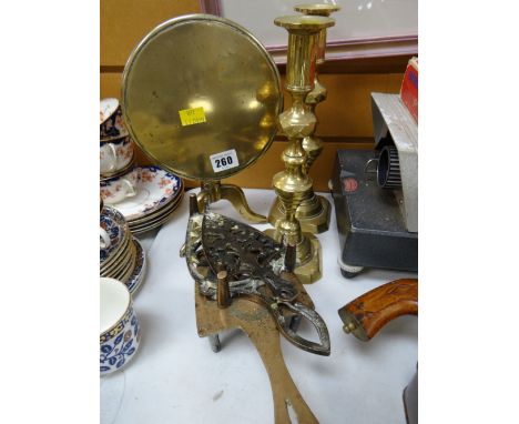 A miniature brass tilt top tripod table, pair of brass candlesticks & three brass trivet stands