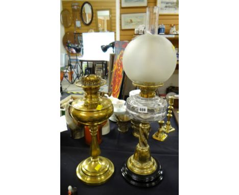 Brass columned clear glass reservoir oil lamp together with a brass oil lamp base