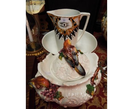 A French Art Deco wash basin and jug together with a continental lidded pot with applied birds, leaves and branches