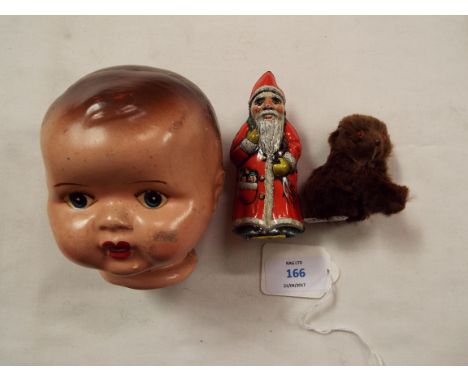 A 1960s Arnold tin plate clock work Santa Claus, a Schuco style brown bear and a vintage composition doll's head