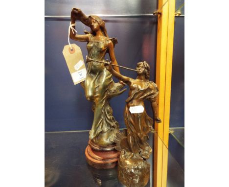 An early 20thC spelter figure of a classical female resting on a crescent moon together with another playing a horn signed Gl