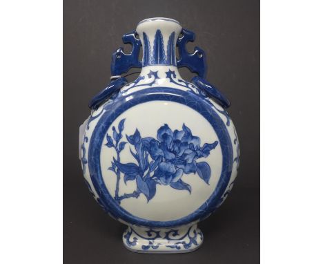 A Chinese blue and white twin handled moon flask, decorated with circular panel depicting a mountainous landscape to one side