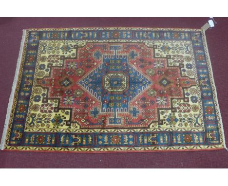 A North West Persian Nahavand rug, diamond shaped central medallion with repeating floral motifs on a terracotta field, guard