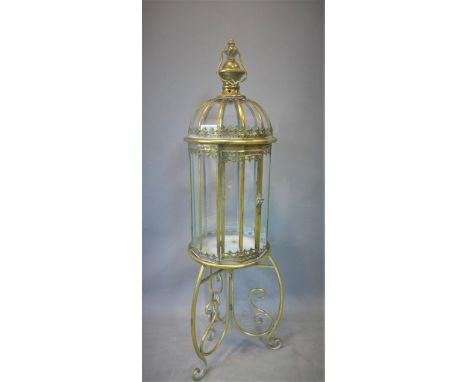 A contemporary gilt metal storm lantern, on stand with three scrolling feet, H.109cm 