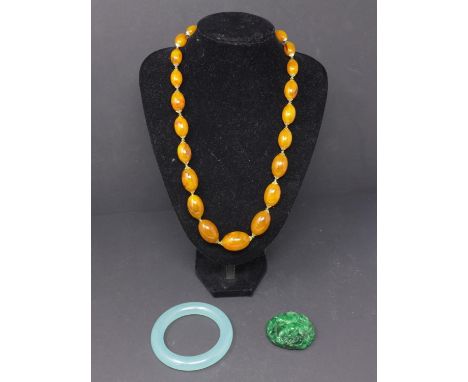 A group of Chinese jewels including a jade bracelet, a hard stone pendant and amber neckless 