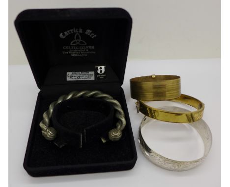 A silver bangle, two rolled gold bangles and a Celtic bangle made of pewter and silver, boxed