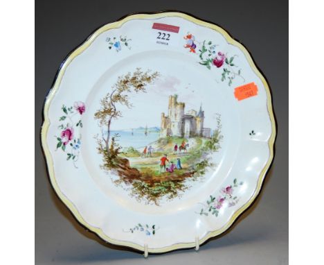 An opaque Luneville of France soft-paste porcelain plate, decorated with extensive coastal landscape within a shaped border, 