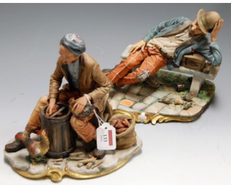 A large mid-20th century Capo di Monte figure of a reclining hobo on a bench, h.21cm; together with one other similar Capo di