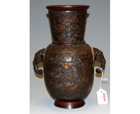 A Chinese bronze vase having tapering neck to baluster body having twin elephant mask handles and all over relief decorated w