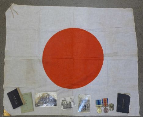 A Japanese flag, two Japanese medals and badge and five Japanese WWII military photographs and three small army manuals