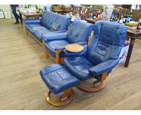 An Ekornes leather four piece lounge suite, in blue, including three seat sofa, armchair, adjustable armchair and footstool (