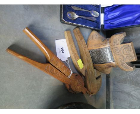 Scandinavian treen comprising two nutcrackers and a carved and decorated two piece item with an applied and decorated piece o