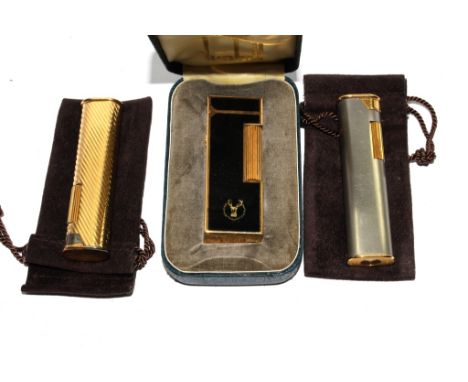 A Dunhill enamel rollagas lighter, with case, a gold plated Dunhill bar lighter and a similar stainless steel lighter 