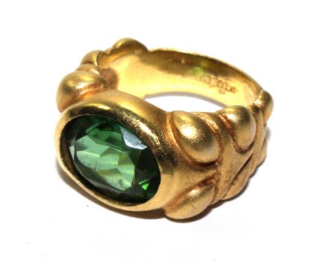 A gold colour ring set with paste stone 