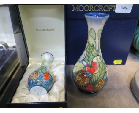 A Moorcroft Enamel Holly and Mistletoe design vase, 10.5 cm high, and a matching Moorcroft pottery vase, 33/150, 17 cm high, 