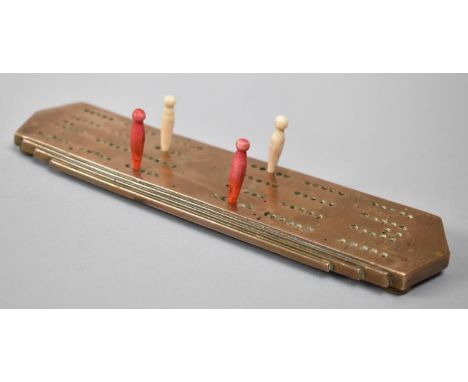 A Small Brass Cribbage Board, the Reverse Stamped Yale ?anercost, with Four Pegs, 20cm Long 