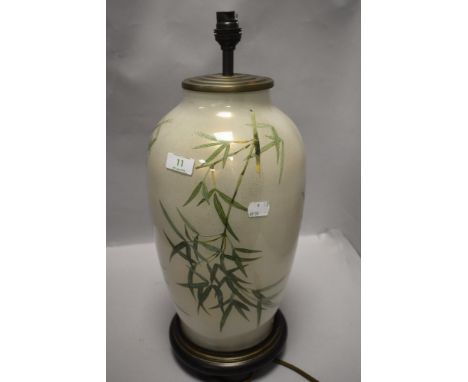 A modern glass table lamp having bamboo pattern with wooden base.