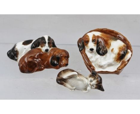 A ROYAL DOULTON CERAMIC COCKER SPANIEL, curled up in a basket, ref. HN2585, together with a ROYAL DOULTON MODEL OF TWO SPANIE