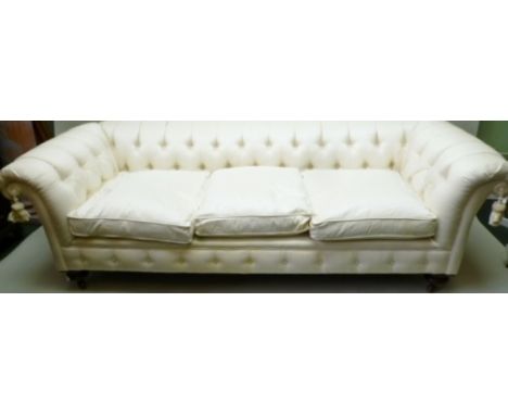 A 19TH CENTURY LOW BACKED CHESTERFIELD SOFA, currently upholstered in ivory silk, having three feather filled squab cushions,