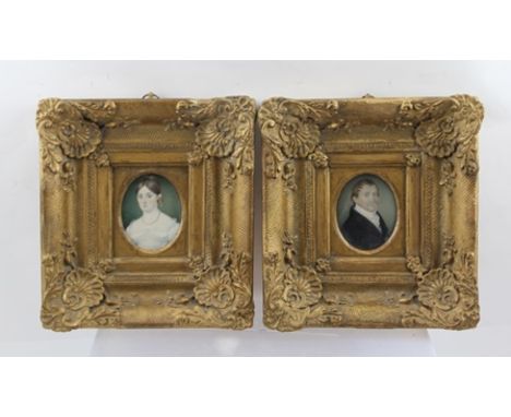 A PAIR OF 19TH CENTURY MINIATURE PORTRAITS of a middle aged couple of substance, he wears a dark frock coat and white cravat,