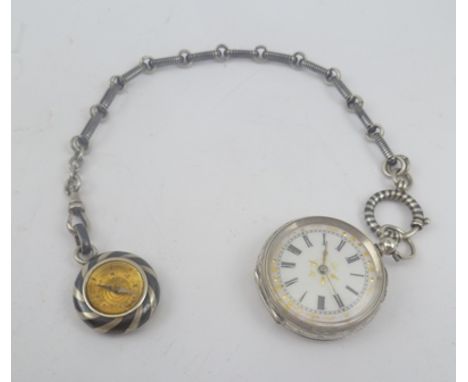 A SILVER FOB WATCH with white dial and chased case, with silver Niello Albert chain and a SILVER AND NIELLO SMALL COMPASS att