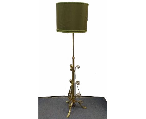 A brass and copper mounted standard lamp, scroll decorated, weighted base with three splayed supports, green shade, 185 cm hi
