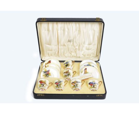 A Royal Worcester cased porcelain coffee set with painted decoration of birds by Ernest Barker, comprising six cups and six s