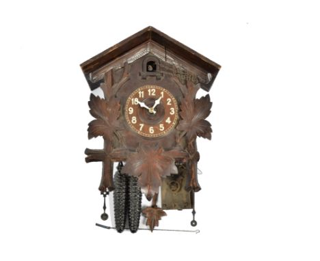 A Black Forest cuckoo clock, chalet case with carved leaf decoration, pineapple weights; together with a 20th Century wooden 