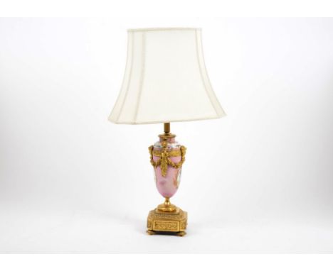 A French porcelain and ormolu mounted table lamp, baluster form decorated with floral and cherub panels on pink ground, mount