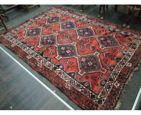 A 20th century carpet square of Eastern design having geometric red and black ground