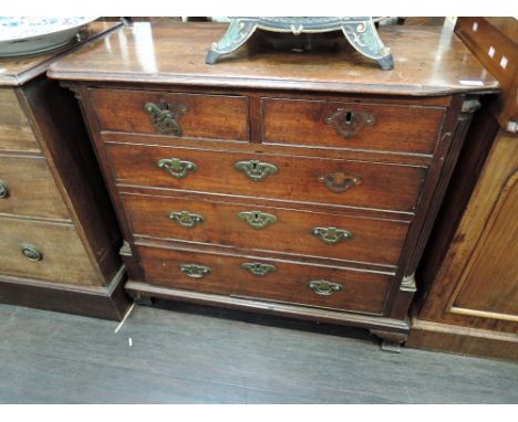 An early 19th century George III mahogany chest of two short and three long cockbeaded drawers, flanked by reeded pillars on 
