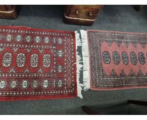Two late 20th century carpet runner/rugs of Turkmen design, on red and pink ground