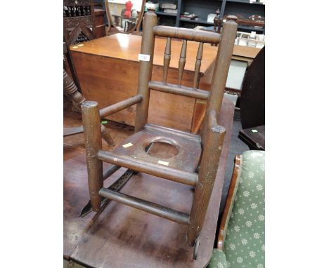 An early 19th century scumbled elm/oak vernacular child's rocking commode armchair