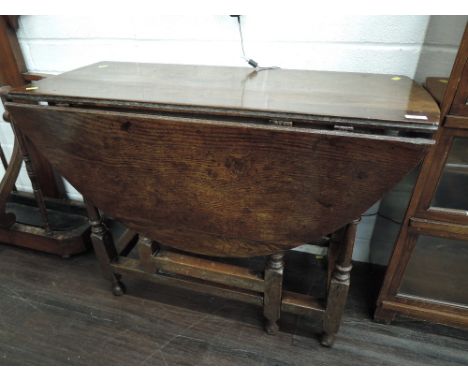 A 19th century oak drop leaf dining table, on ring turned gate legs, in the 18th century style