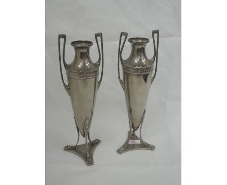 A pair of WMF plated urns of Grecian form having architectural style handles and trefoil animalistic feet to pedestal base