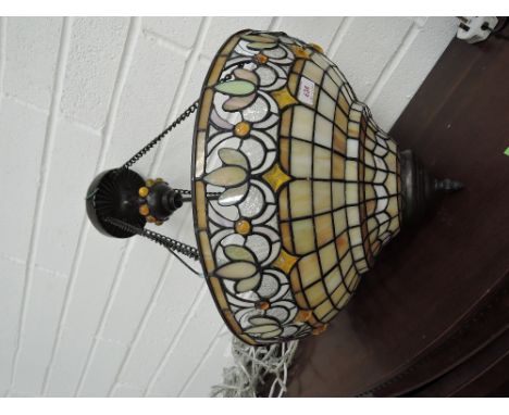 A Tiffany style reproduction ceiling lamp having stylised shade in brown with chain