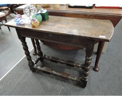 An 18th century oak dining table centre on bobbin legs