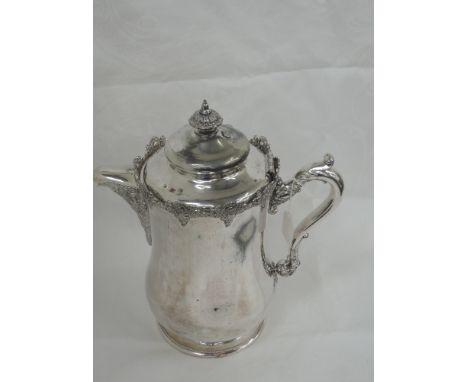 An over sized silver plated lidded pitcher by  Victor Silver Co having a ceramic lining and moulded floral swag decoration to