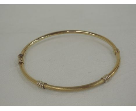 A 9ct gold hinged sprung bangle of tubular form having band and brushed decoration,  approx 4.6g