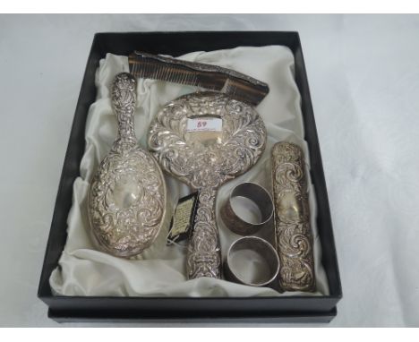 A four piece silver dressing table set having moulded scroll and mask decoration, Birmingham 1971, W I Broadway & Co, (comb a